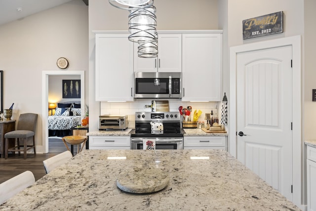 359 Green St, Santee, SC 29142 - kitchen with appliances with stainless steel finishes, white cabinets, decorative backsplash, and light stone counters