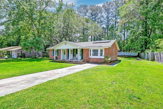 403 Forest Cir, Summerville, SC 29483 - view of front facade featuring roof mounted solar panels, a porch, a front lawn, and brick siding