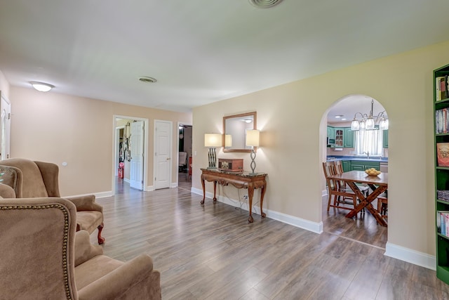 403 Forest Cir, Summerville, SC 29483 - living room featuring baseboards, arched walkways, wood finished floors, and a chandelier