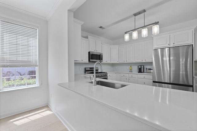 132 Fresh Meadow Ln, Mount Pleasant, SC 29466 - kitchen featuring appliances with stainless steel finishes, light countertops, white cabinetry, light wood-style floors, and ornamental molding