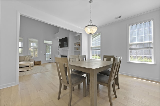 132 Fresh Meadow Ln, Mount Pleasant, SC 29466 - dining room with a fireplace, ornamental molding, light wood-style flooring, and built in features