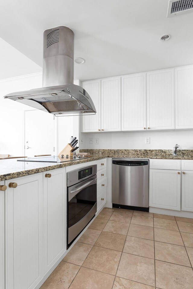 5802 Palmetto Dr Unit B-521/519, Isle Of Palms, SC 29451 - kitchen with stainless steel appliances, island exhaust hood, white cabinets, and light tile patterned flooring