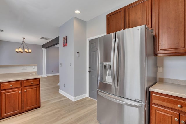 kitchen with light hardwood / wood-style floors, an inviting chandelier, stainless steel refrigerator with ice dispenser, and hanging light fixtures