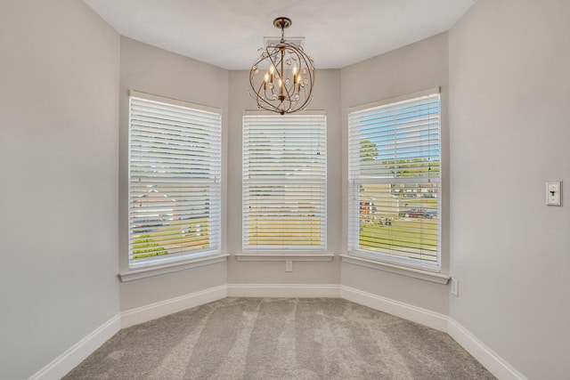 unfurnished room with a notable chandelier, carpet flooring, and a wealth of natural light