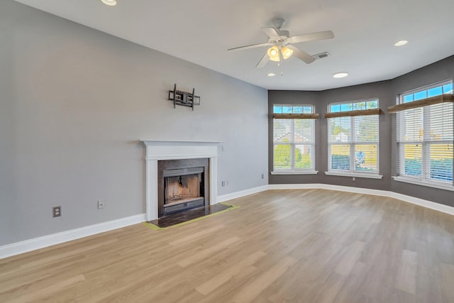 unfurnished living room with light wood-type flooring and ceiling fan