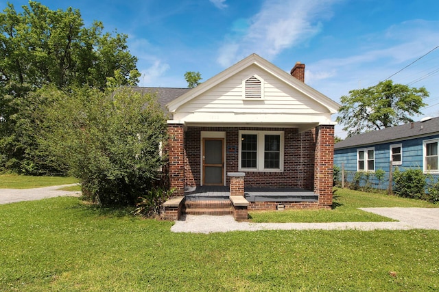 view of front of house featuring a front lawn and covered porch