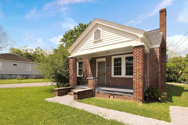 view of front of property featuring covered porch and a front lawn