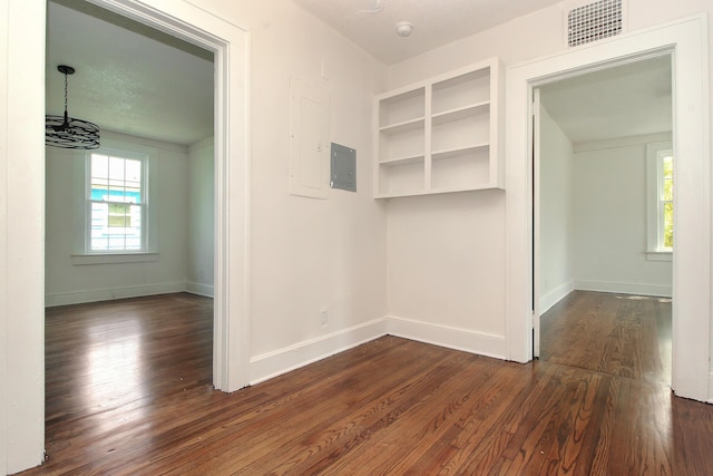 interior space with electric panel, dark hardwood / wood-style flooring, and a textured ceiling