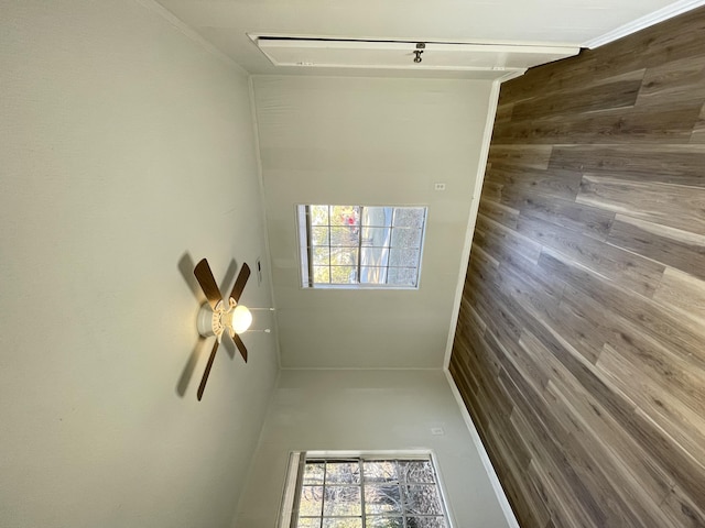 empty room featuring ceiling fan and wooden walls