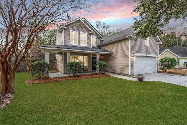 view of property featuring a lawn, a porch, and a garage