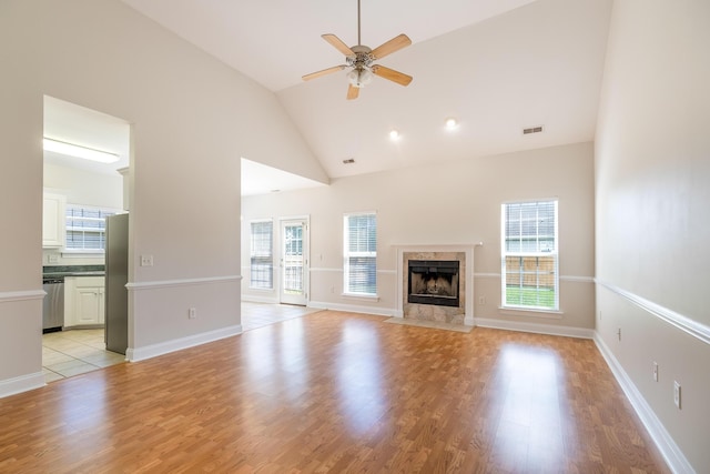 7812 Spring Creek Rd, North Charleston, SC 29418 - unfurnished living room featuring a ceiling fan, a tiled fireplace, light wood finished floors, and high vaulted ceiling