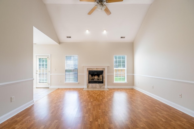 7812 Spring Creek Rd, North Charleston, SC 29418 - unfurnished living room with ceiling fan, a tiled fireplace, light wood-type flooring, and high vaulted ceiling