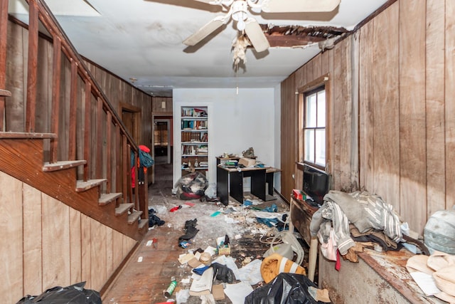 interior space featuring wood walls, stairway, and a ceiling fan