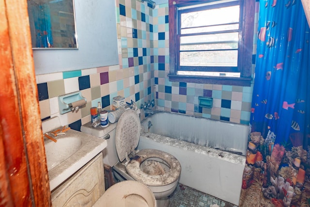 bathroom featuring shower / bath combination with curtain, vanity, toilet, and tile walls