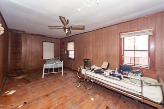 miscellaneous room with a ceiling fan, wood walls, and hardwood / wood-style flooring