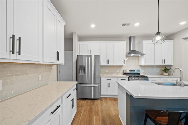 217 Lucca Dr, Summerville, SC 29486 - kitchen featuring visible vents, appliances with stainless steel finishes, white cabinets, a sink, and wall chimney range hood