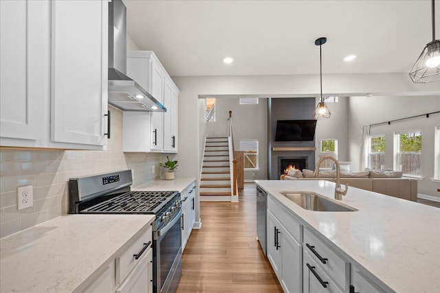 217 Lucca Dr, Summerville, SC 29486 - kitchen with white cabinets, open floor plan, stainless steel appliances, wall chimney range hood, and a sink