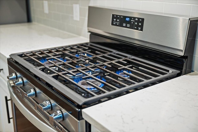 217 Lucca Dr, Summerville, SC 29486 - room details with light countertops, backsplash, stainless steel range with gas cooktop, and white cabinetry