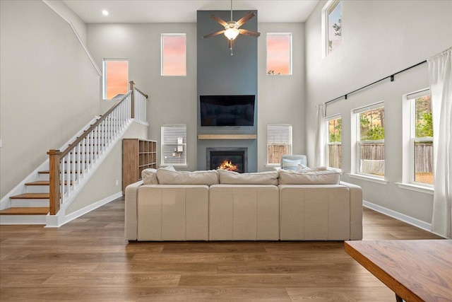 217 Lucca Dr, Summerville, SC 29486 - living area with stairway, a high ceiling, a large fireplace, wood finished floors, and baseboards