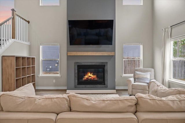 217 Lucca Dr, Summerville, SC 29486 - living area featuring a towering ceiling, baseboards, wood finished floors, and a glass covered fireplace