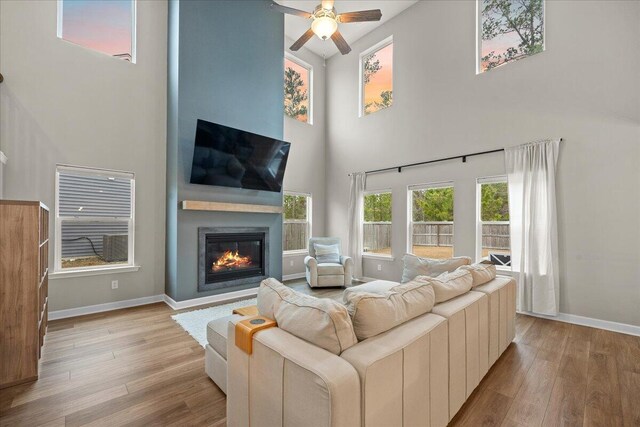 217 Lucca Dr, Summerville, SC 29486 - living room featuring light wood-type flooring, baseboards, a ceiling fan, and a glass covered fireplace