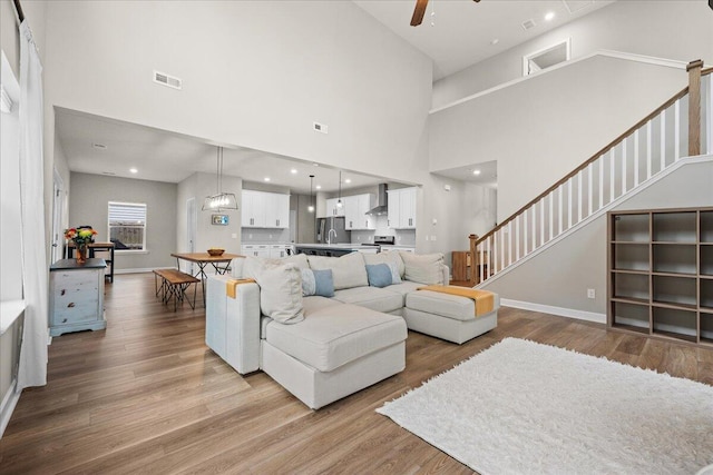 217 Lucca Dr, Summerville, SC 29486 - living room with light wood finished floors, ceiling fan, stairs, and visible vents