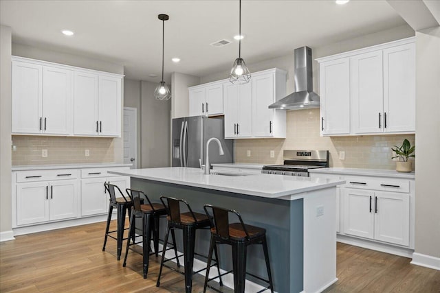 217 Lucca Dr, Summerville, SC 29486 - kitchen featuring white cabinets, wall chimney exhaust hood, stainless steel appliances, light countertops, and a sink