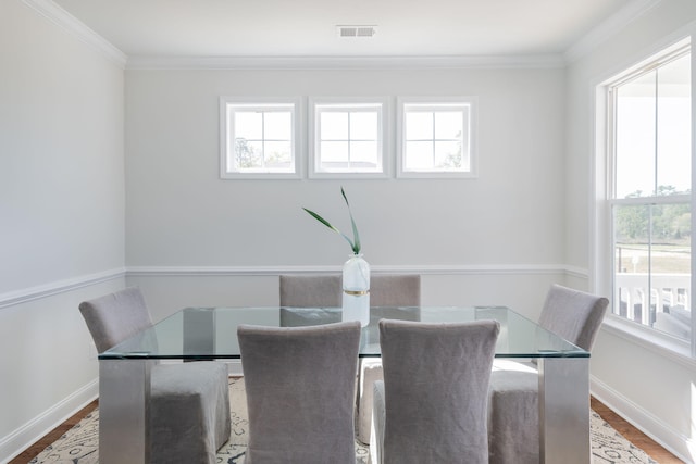 dining space with ornamental molding, a healthy amount of sunlight, and hardwood / wood-style flooring