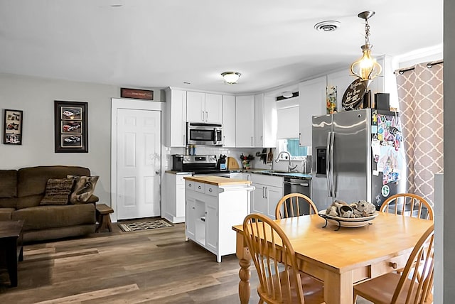 kitchen featuring visible vents, a sink, wood counters, white cabinetry, and stainless steel appliances