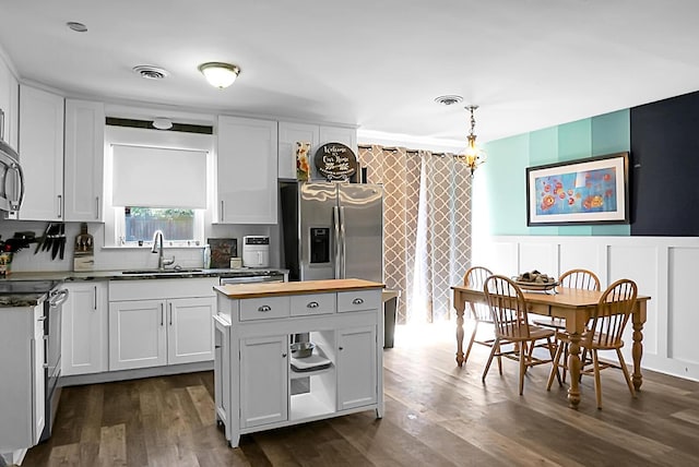 kitchen featuring dark wood-style floors, visible vents, wood counters, and a sink