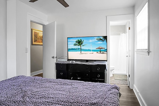 bedroom with ceiling fan, ensuite bath, baseboards, and wood finished floors