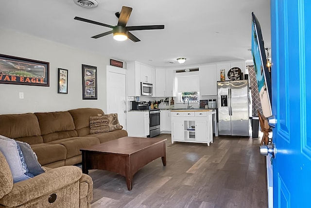 living room featuring visible vents, dark wood-style flooring, and ceiling fan