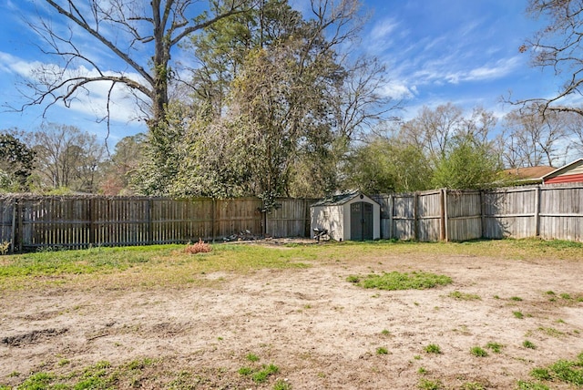 view of yard with an outbuilding, a storage shed, and a fenced backyard