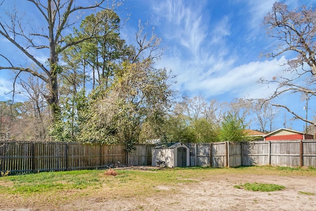 view of yard with an outbuilding, a fenced backyard, and a storage shed