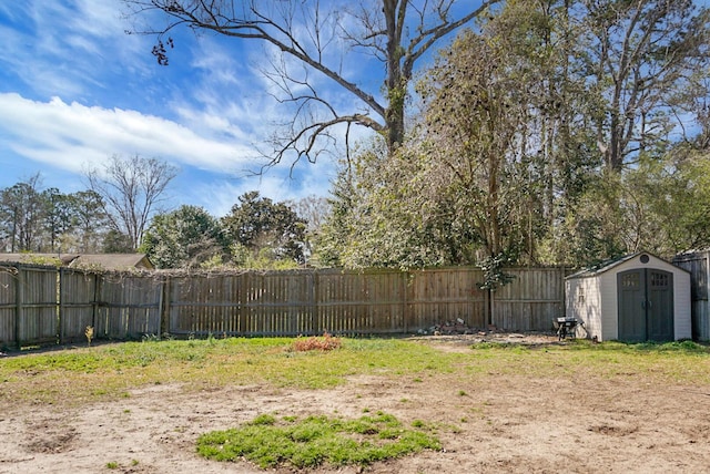 view of yard with an outbuilding, a fenced backyard, and a shed