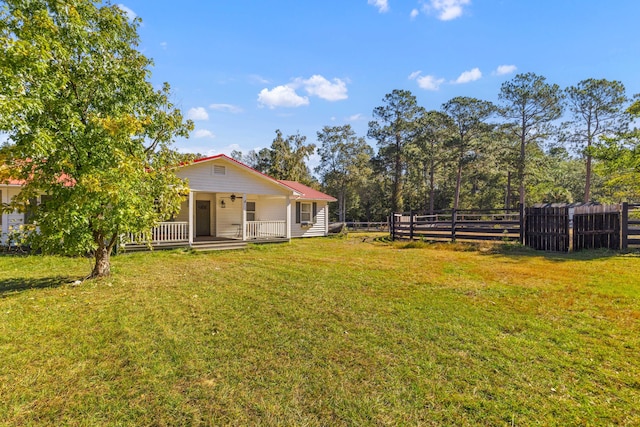 view of yard with covered porch and fence