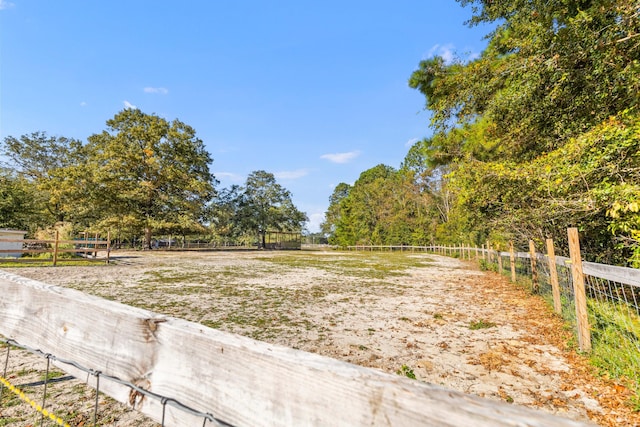 view of yard with a rural view and fence