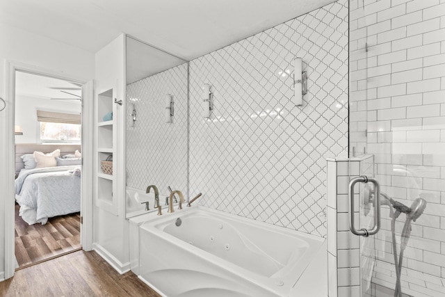 ensuite bathroom with ensuite bath, a jetted tub, wood finished floors, and a tile shower