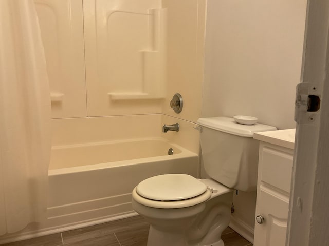 full bathroom with hardwood / wood-style flooring, shower / bath combination with curtain, vanity, and toilet