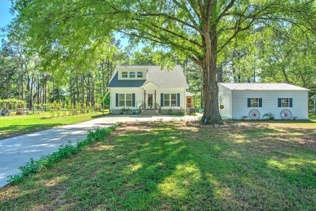 bungalow-style home with concrete driveway and a front lawn