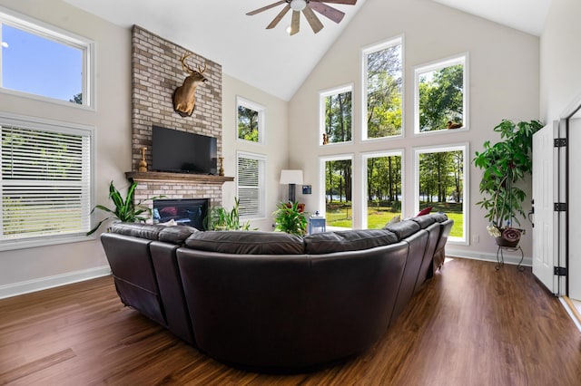 living area featuring high vaulted ceiling, a brick fireplace, baseboards, and ceiling fan