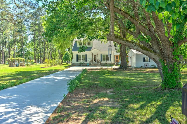 view of front of house with concrete driveway, a shingled roof, and a front lawn