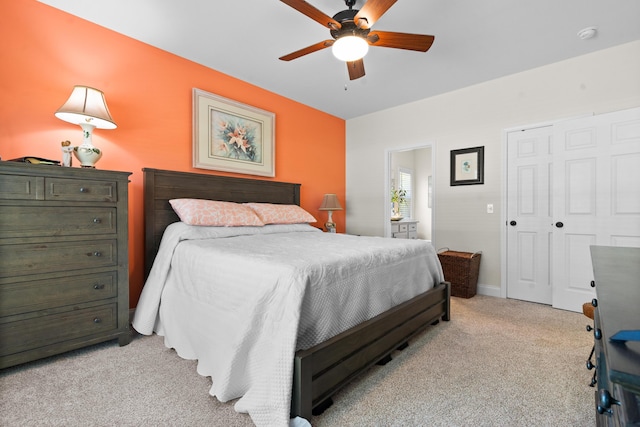 bedroom with a closet, ceiling fan, and light colored carpet