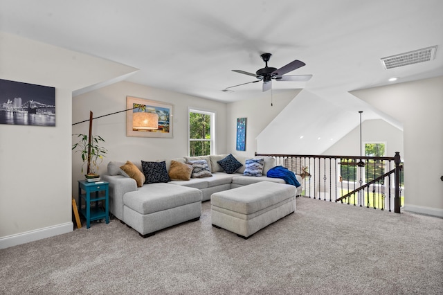 living room with carpet, visible vents, baseboards, and a ceiling fan