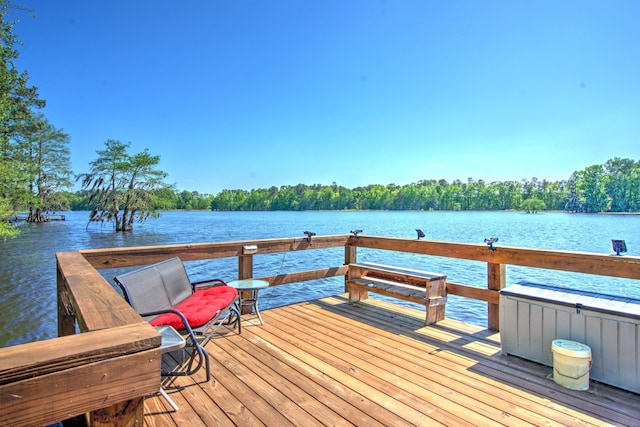 view of dock featuring a forest view and a water view