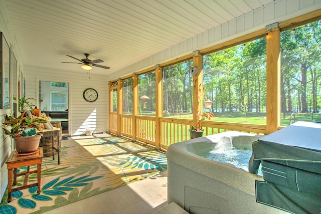 sunroom featuring a jacuzzi, ceiling fan, and a healthy amount of sunlight