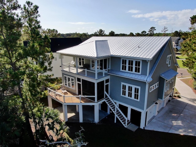 rear view of property with a garage and a balcony