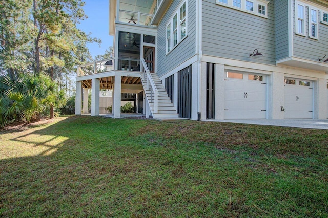 rear view of house with a yard, a garage, and a sunroom