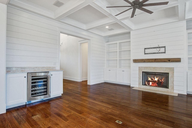 unfurnished living room with dark hardwood / wood-style flooring, coffered ceiling, beam ceiling, and beverage cooler