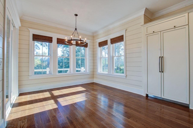 unfurnished dining area featuring wood walls, dark hardwood / wood-style floors, and a chandelier